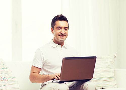 technology, people lifestyle and networking concept - happy man working with laptop computer at home