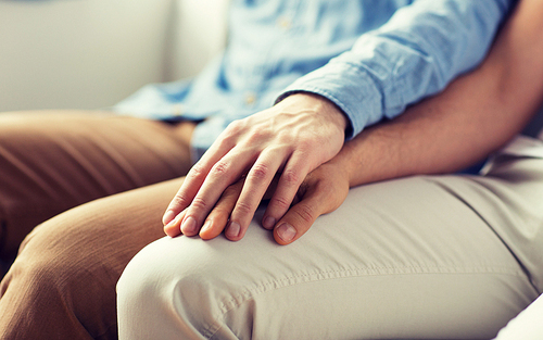 people, homosexuality, same-sex marriage, gay and love concept - close up of happy male gay couple holding hands