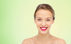 beauty, people and health concept - smiling young woman face with pink lipstick on lips and shoulders over green natural background