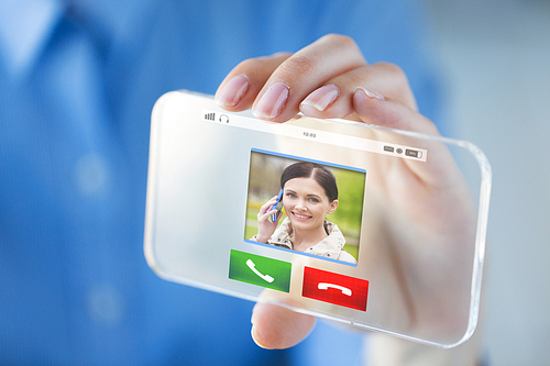 business, technology, communication and people concept - close up of woman hand holding and showing incoming call on transparent smartphone screen