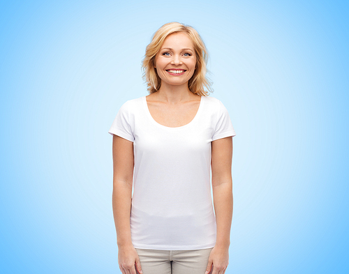 happiness and people concept - smiling middle aged woman in blank white t-shirt over blue background