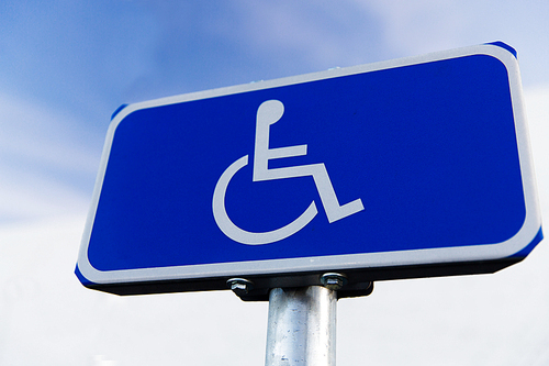 traffic laws and highway code concept - close up of road sign for disabled outdoors