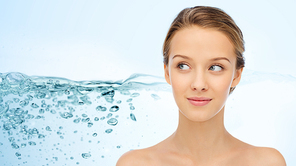 beauty, people, moisturizing, skin care and health concept - smiling young woman face and shoulders over water splash background