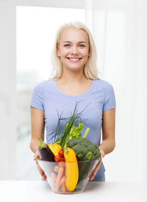 healthy eating, vegetarian food, dieting and people concept - smiling young woman with bowl of vegetables at home