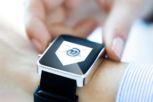 business, technology, communication, connection and people concept - close up of hands with email icon on smartwatch