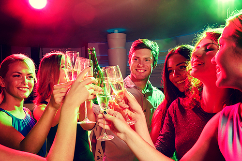 party, holidays, celebration, nightlife and people concept - smiling friends clinking glasses of champagne and beer in club