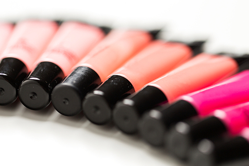 cosmetics, make up and beauty concept - close up of lip gloss tubes