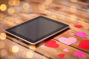 advertisement, romance, valentines day and holidays concept - close up of tablet pc computer and hearts on wood