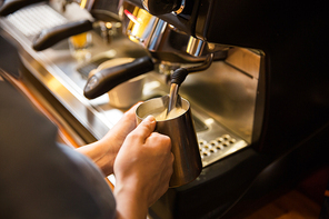 equipment, coffee shop, people and technology concept - close up of woman making coffee by machine at cafe bar or restaurant kitchen