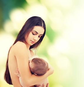 family, children, parenthood and happiness concept - happy mother feeding her adorable baby