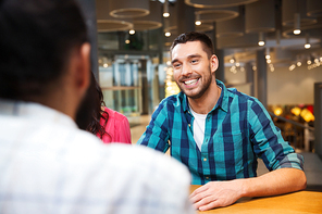 leisure, communication and people concept - happy smiling man meeting with friends at restaurant