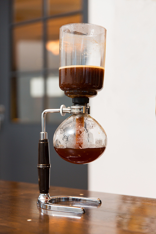 equipment, coffee shop and technology concept - close up of siphon vacuum coffee maker at shop