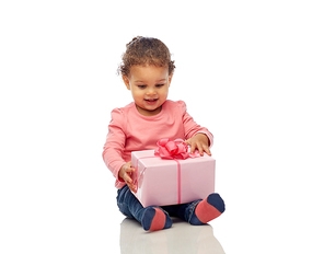 childhood, fashion, birthday, holidays and people concept - happy smiling little african american baby girl with gift box sitting on floor