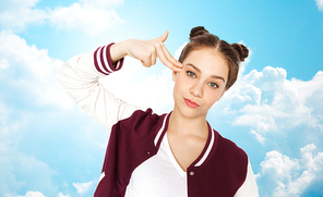 people, emotion, expression, stress and teens concept - bored teenage girl making headshot by finger gun gesture over blue sky and clouds background