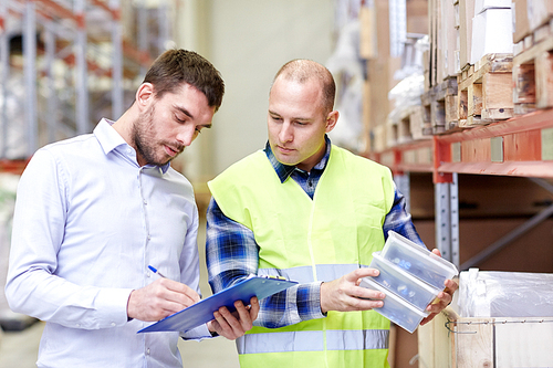wholesale, logistic, people and export concept - manual worker and businessmen with clipboard and boxes at warehouse
