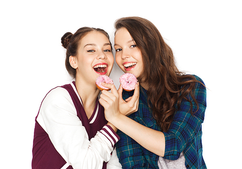 people, friends, teens and friendship concept - happy smiling pretty teenage girls with donuts eating and having fun