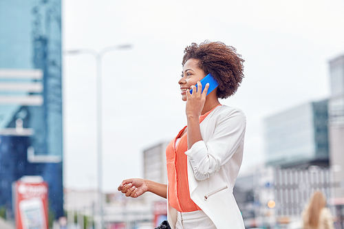 business, communication, technology and people concept - young smiling african american businesswoman calling on smartphone in city