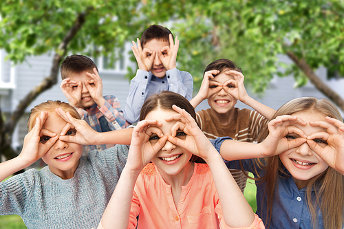 childhood, fashion, friendship and people concept - happy children making faces and having fun over private house backyard background