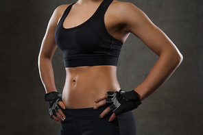 sport, fitness, bodybuilding, sportswear and people concept - close up of young woman body in gym