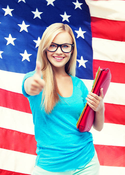 student with folders showing thumbs up over american flag