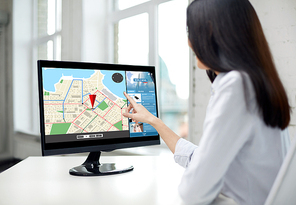 business, people, technology and navigation concept - close up of woman pointing finger to gps navigator map on computer monitor in office