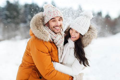 people, season, love and leisure concept - happy couple hugging and laughing outdoors in winter