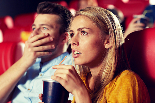 cinema, entertainment and people concept - couple drinking soda and watching drama or thriller movie in theater