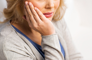 people, healthcare, dentistry and problem concept - close up of unhappy woman suffering toothache at home