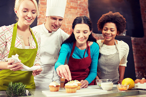 cooking class, culinary, bakery, food and people concept - happy group of women and male chef cook baking in kitchen