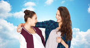 people, friends, teens and friendship concept - happy smiling pretty teenage girls hugging over blue sky and clouds background