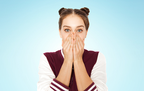 people, emotion, expression and teens concept - scared or confused teenage girl over blue background