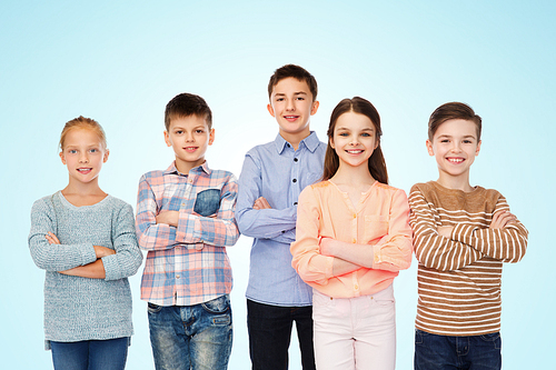 childhood, fashion, friendship and people concept - happy smiling children over blue background