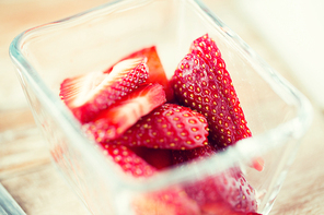 fruits, berries, diet, eco food and objects concept - juicy fresh ripe red strawberries in glass bowl