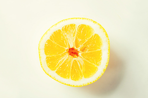 fruits, citrus, diet and objects concept - ripe orange or lemon slice over white