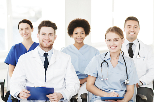 hospital, profession, people and medicine concept - group of happy doctors on seminar in lecture hall at hospital