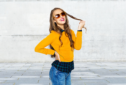 people, style and fashion concept - happy young woman or teen girl in casual clothes and sunglasses over urban street background