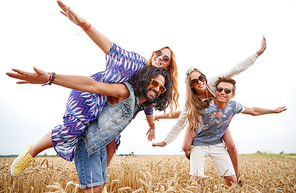 nature, summer, youth culture and people concept - happy young hippie friends having fun on cereal field