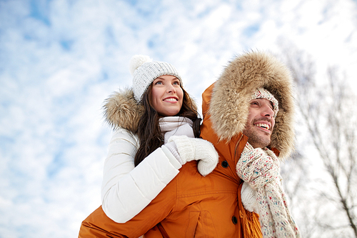 people, season, love and leisure concept - happy couple having fun over winter background