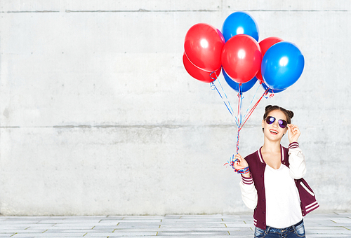 people, teens, holidays, party and summer concept - happy smiling pretty teenage girl in sunglasses with helium balloons over gray stone wall background