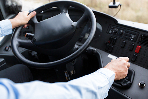 transport, transportation, tourism, road trip and people concept - close up of bus driver steering wheel and driving passenger bus