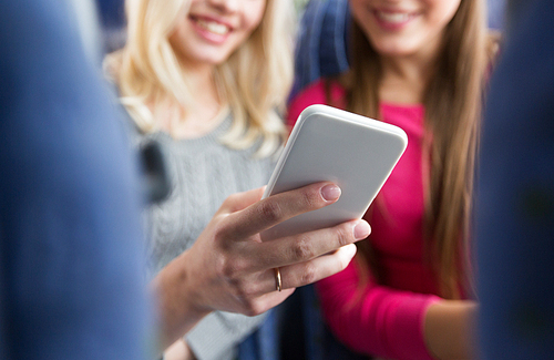 transport, tourism, road trip and people concept - close up of women in travel bus texting or reading message on smartphone