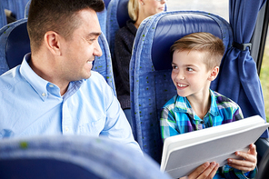 travel, tourism, family, technology and people concept - happy father and son with tablet pc computer sitting in travel bus