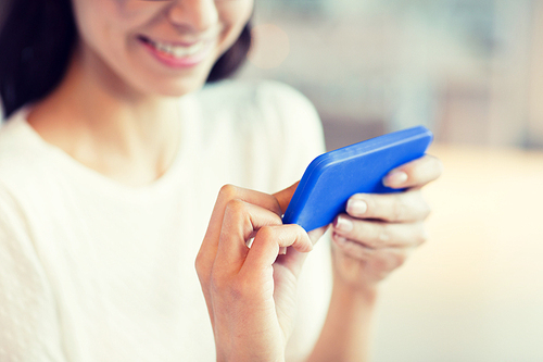 people, technology and lifestyle concept - close up of woman with smartphone at cafe