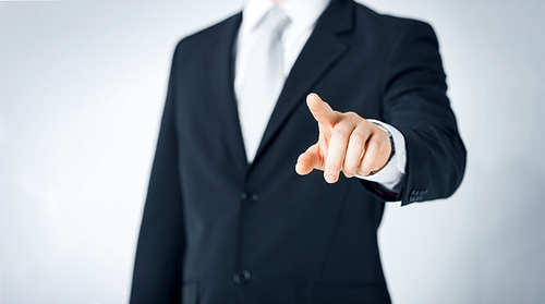 people, business and gesture concept - close up of man pointing finger to to something