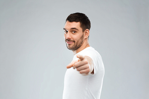 gesture and people concept - man pointing finger to you over gray background