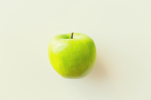 fruits, diet,  food and objects concept - ripe green apple over white