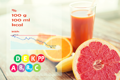 healthy eating, food and diet concept - close up of fresh juice glass and fruits on table with calories and vitamin chart