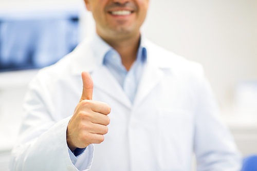 gesture, health care, people and medicine concept - close up of happy male doctor showing thumbs up at hospital