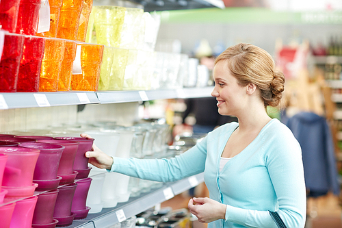 people, gardening, shopping, sale and consumerism concept - happy woman choosing flower pot in shop