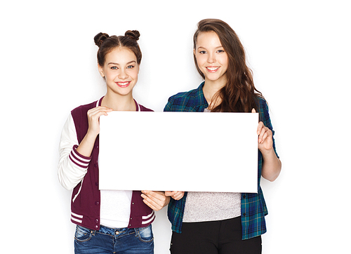 people, friends, teens and friendship concept - happy smiling pretty teenage girls holding and showing white blank board